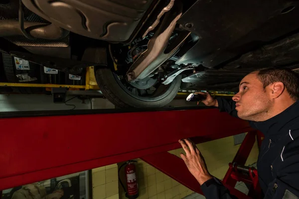 Mecánico automático trabajando en taller mecánico. Comprobación de frenos y suspensiones — Foto de Stock