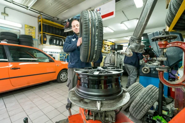 Mécanicien automobile travaillant dans un atelier mécanique. Remplacement des pneus . — Photo