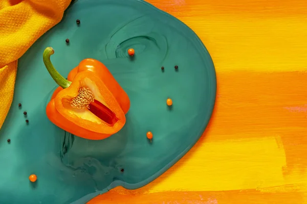 Sliced orange sweet juicy bell pepper with seeds inside on a bright blue smalt board — Stock Photo, Image