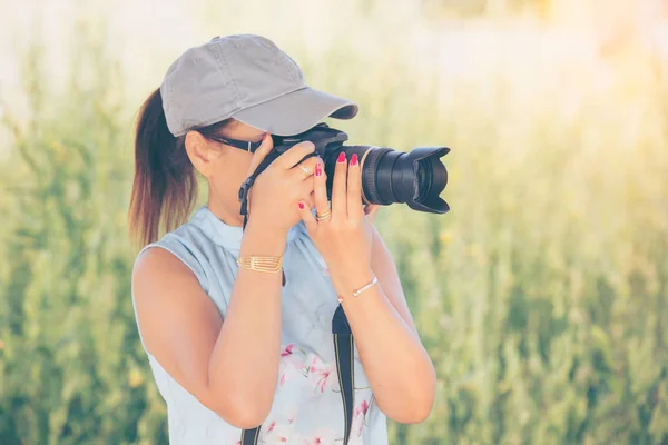 Mulher é um fotógrafo profissional com câmera dslr, ao ar livre um — Fotografia de Stock