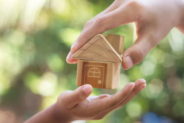 La mano está dando un modelo de una casa a la mano del niño , — Foto de Stock