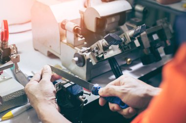 Atölyedeki çilingir yeni anahtar yapıyor. Profesyonel yapım anahtarı 