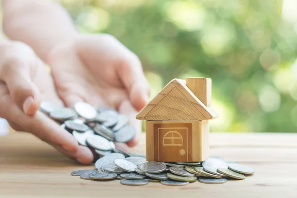 Hus placeras på mynt mäns hand planerar besparingar pengar — Stockfoto