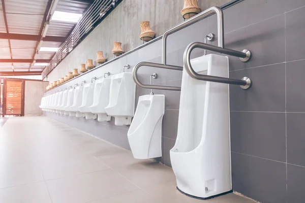 Baño de hombres con urinarios de porcelana blanca en línea. Moderno pu limpio — Foto de Stock