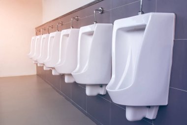 Beyaz porselen pisuarların sıralı olduğu erkekler tuvaleti. Modern temiz pu