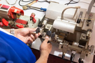 Atölyedeki çilingir yeni anahtar yapıyor. Çilingirde anahtar yapan bir profesyonel. Kopya metal anahtarın makine üretimi.