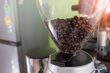 Kahve çekirdekleri öğütücüye, yakın plan. Mesaj için yer var. Kahve öğütücüsü, kahve dükkanı..