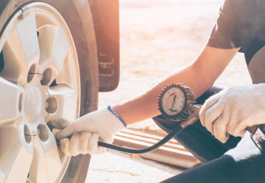 Asya adam araba denetim Ölçü miktarı Şişirilmiş Kauçuk lastikler araba. Otomotiv, otomobil imajı için otomobil lastiği basınç ölçümü için yakın el tutma makinesi Şişirilmiş basınç göstergesi