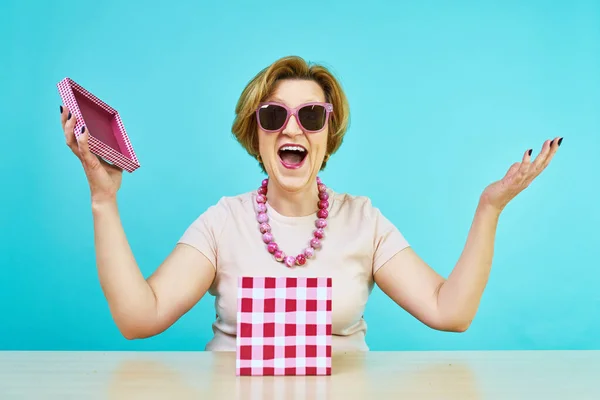 Grappig opgewonden oude vrouw. Een vrouw in leeftijd was erg blij om geschenken te ontvangen. bedrijf geopend aanwezig vak geïsoleerd over blauwe achtergrond — Stockfoto