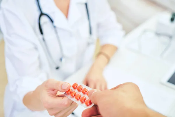 Voorschrift van een arts voor de behandeling van ziekten. De dokter geeft blauwe pillen. farmacologisch concept — Stockfoto