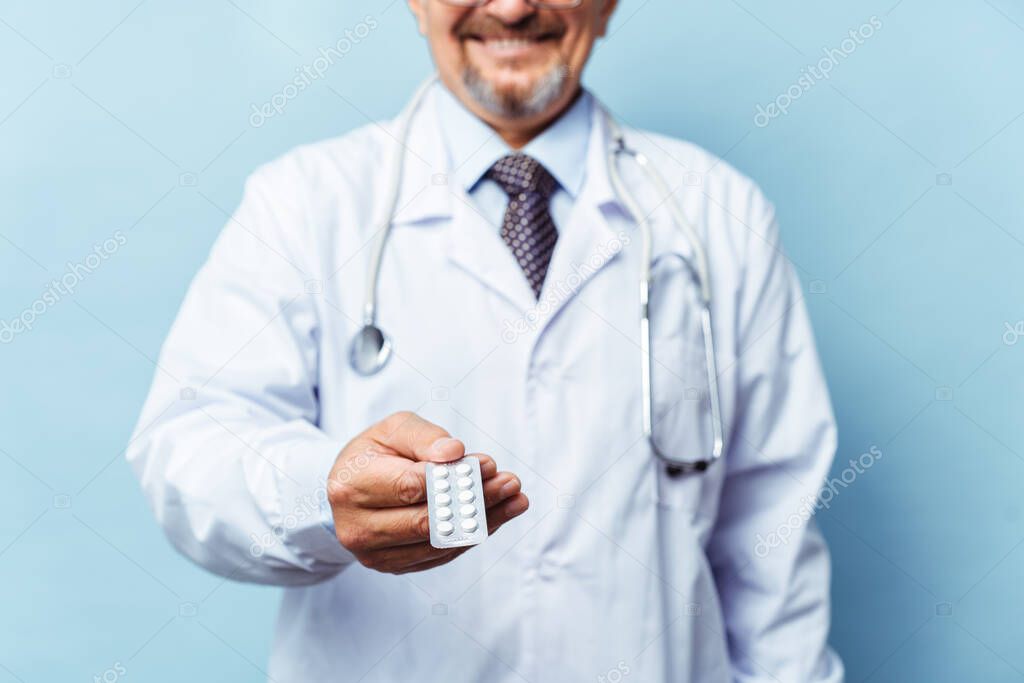 Doctor giving medicine pills. on blue background. The concept of medicine, pharmacology, healthcare.
