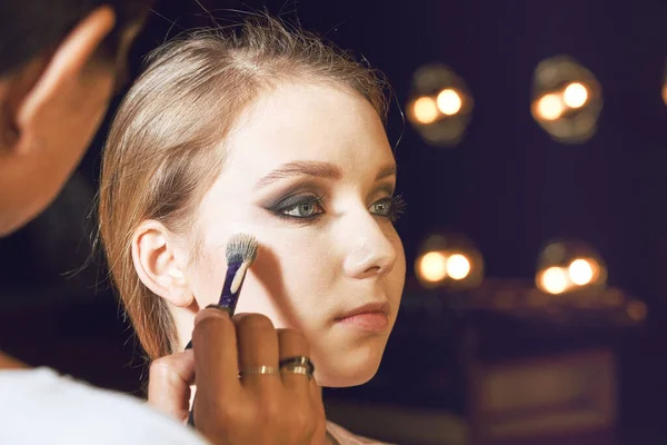Maquillaje artista aplicando base tonal líquida en la cara de la mujer — Foto de Stock