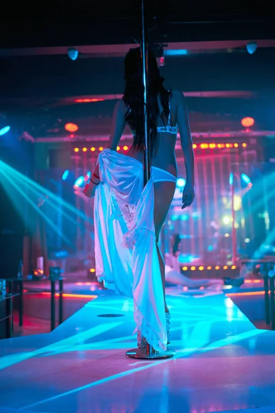 Ung sexig kvinna pole dans striptease med pylon i nattklubb. Vacker naken strippa flicka på scenen. Vackra kvinnliga ben i högklackade skor remsor — Stockfoto