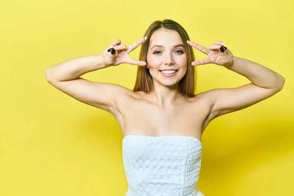 Retrato de una mujer joven y bonita. Chica feliz mirando a la cámara y sonriendo lindo. Fondo amarillo —  Fotos de Stock