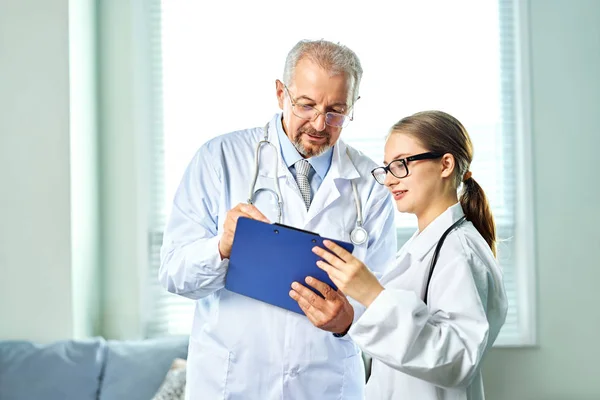 El equipo médico está discutiendo la conferencia para examinar el diagnóstico de su informe médico del paciente en la sala de examen juntos. Médicos Médicos Trabajo en equipo y Medicina Concepto de Salud —  Fotos de Stock