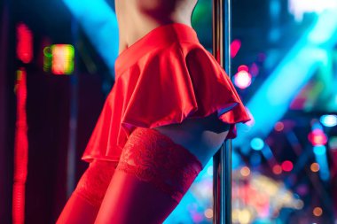 Gece kulübünde direkli striptiz yapan genç seksi kadın. Güzel striptizci kız sahnede.