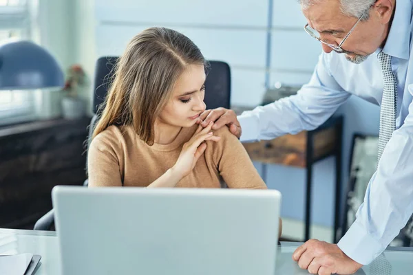 Harassment with a boss touching the arm to his secretary who is sitting in his workplace at office — Stock Photo, Image