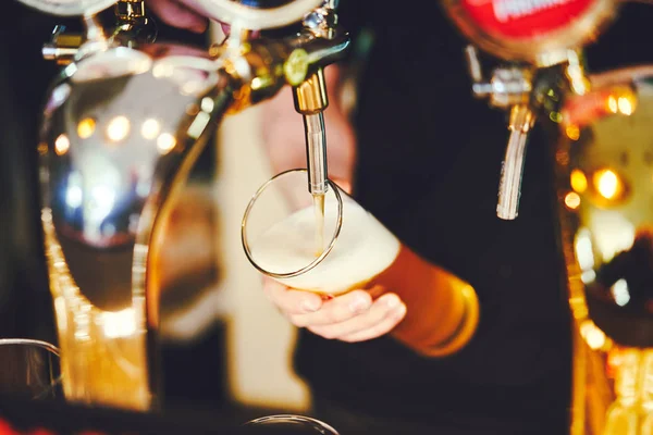 Бармен вливає пиво в келих з крана — стокове фото