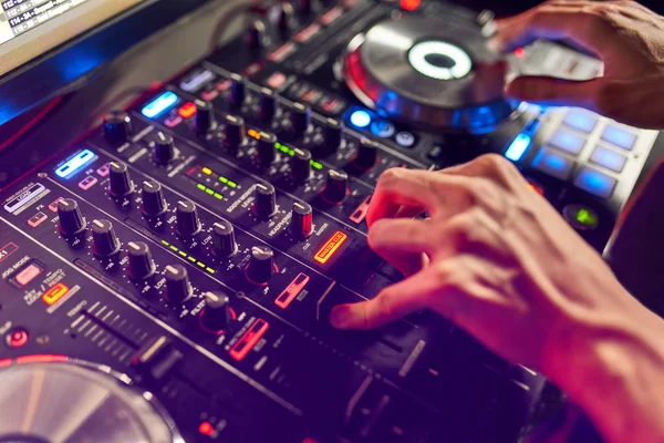 DJ mischt den Track im Nachtclub bei der Party auf. im Hintergrund Laserlichtshow — Stockfoto