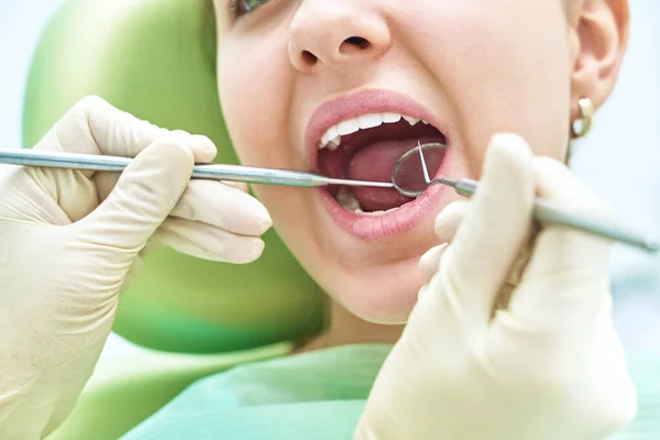 Girl sitting at dental chair with open mouth during oral check up while doctor. Visiting dentist office. Dentistry concept. — Stockfoto