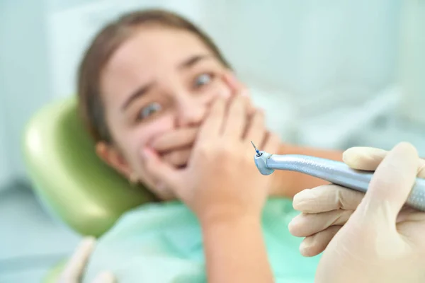 Dziewczyna siedząca na krześle dentystycznym z otwartymi ustami podczas badania lekarskiego. Odwiedzam gabinet dentystyczny. Koncepcja dentystyczna. — Zdjęcie stockowe