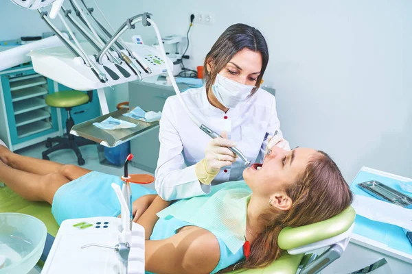 Dziewczyna siedząca na krześle dentystycznym z otwartymi ustami podczas badania lekarskiego. Odwiedzam gabinet dentystyczny. Koncepcja dentystyczna. — Zdjęcie stockowe