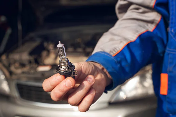 Car service men. Replacing a burnt out lamp in the car headlight — Stock Photo, Image