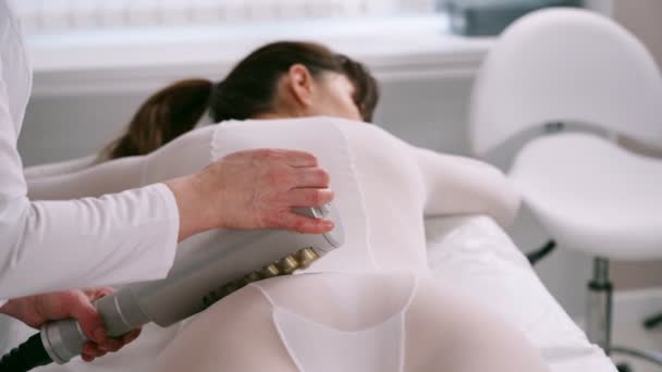 Massaggiatore fa apparecchio anti-cellulite massaggio nella clinica di cosmetologia — Video Stock