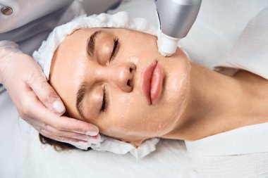 Yüz bakımı. Kozmetik Güzellik Kliniği 'nde kadınların yüz bakımı mikro cilt bakımı yaptırırken yakın plan çekimleri. Hidra Elektrik süpürgesi temizleyicisi. Deri dökülmesi, gençleştirme ve susuzluk. Kozmetoloji.