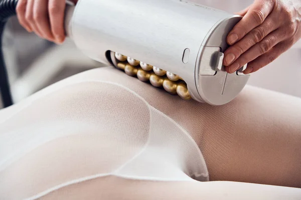 Masażysta wykonuje aparaturę do masażu antycellulitowego w klinice kosmetologii — Zdjęcie stockowe