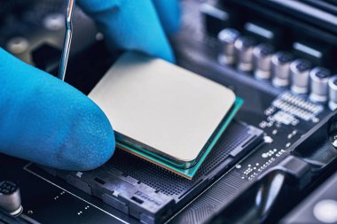 Bilgisayar teknolojisinin elektronik mühendisi. İşlemciyi ana karta yerleştiriyorum. Bilgisayar onarımı, teknisyen ve endüstri destek kavramı.