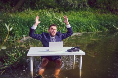 İflas senetlerinin düşüşüyle sarsılmış depresif bir adam iş yerinde dizüstü bilgisayarla oturuyor ve yorgun işadamının umutsuzluğa kapıldığını düşünüyor. Bataklıkta iş..