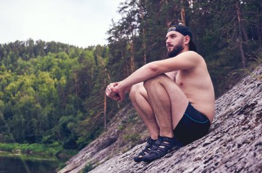 Hayatın tadını çıkarıyorum. Genç bir adam ormanda bir ordugahta yatıyor rahatlama, tatiller, yaşam tarzı konsepti.