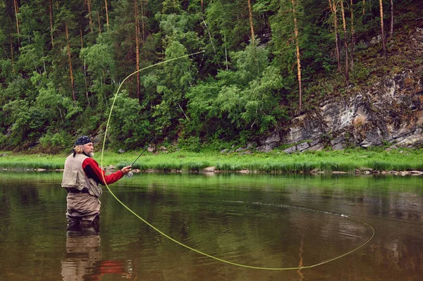 Рыбак-мухоловка делает бросок, стоя в воде — стоковое фото