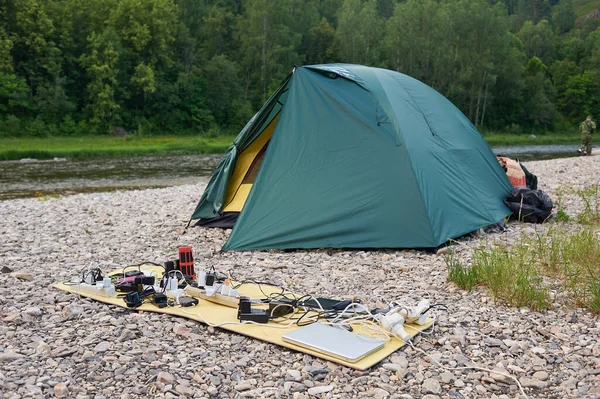 solar panel lying on the ground and charges the smart phone, the Sahara desert. Charge smart phone from the solar battery. Mobile generator in a campaign.