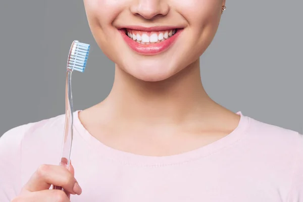 Meisje met gezonde witte tanden houdt een tandenborstel en glimlacht. Concept mondhygiëne — Stockfoto