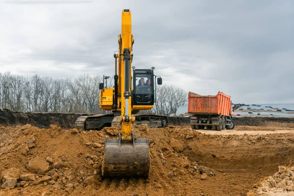 Una gran excavadora de construcción de color amarillo en el sitio de construcción en una cantera para la extracción. Imagen industrial — Foto de Stock