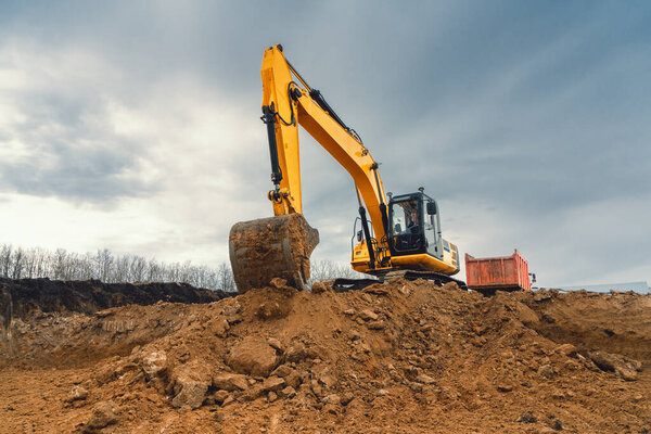 A large construction excavator of yellow color on the construction site in a quarry for quarrying. Industrial image