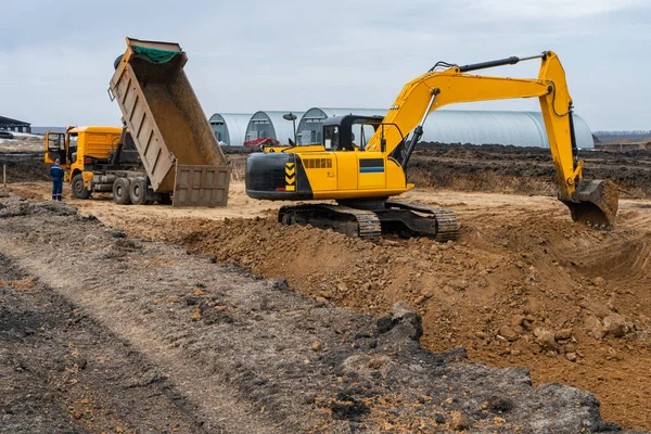 Una gran excavadora de construcción de color amarillo en el sitio de construcción en una cantera para la extracción. Imagen industrial — Foto de Stock