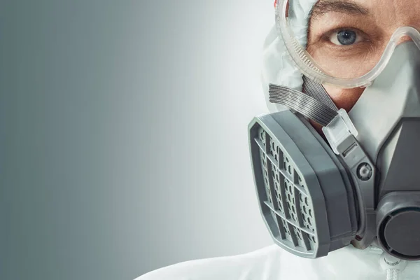 Portrait of a male doctor in a respirator, goggles and a biological protection suit against coronavirus infection. COVID-19 protection. — Stock Photo, Image