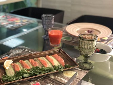 Lezzetli Philadelphia 'yı panoramik pencereden bakan bir masanın üzerine yuvarlıyor. Kış sokağı, laptopun yanındaki atmosferde çalışıyor.