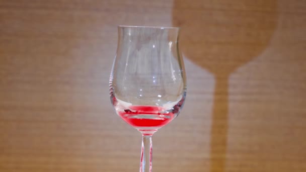 Liquide rouge remplit gobelet en verre — Video