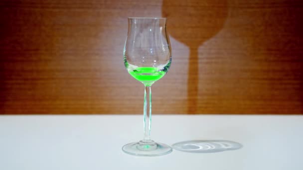 Glazen beker vult zich met groene vloeistof — Stockvideo