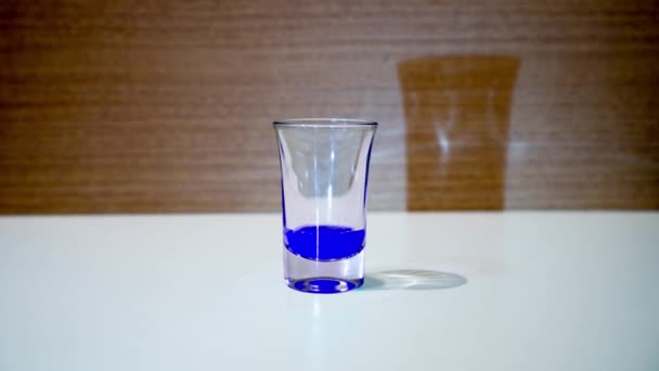 Стакан наполнен голубой жидкостью — стоковое видео