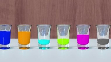 Shot bardakları farklı renklerde alkolle doludur.