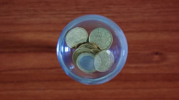 Las monedas llenan la copa de vidrio en stop motion — Vídeo de stock