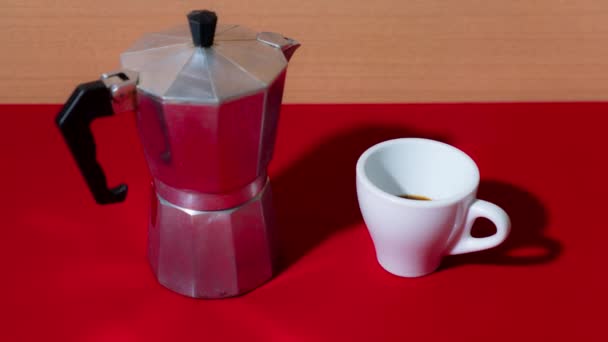 Il caffè riempie la tazza in stop motion sul tavolo rosso — Video Stock
