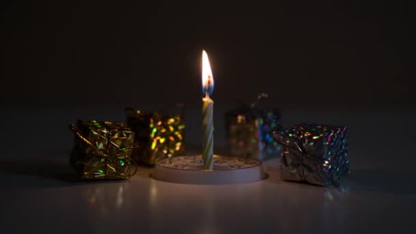 Quemaduras de velas frente a paquetes de regalo — Vídeos de Stock