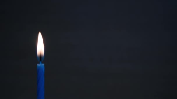 Спалювання свічки в часовий проміжок на темному фоні — стокове відео
