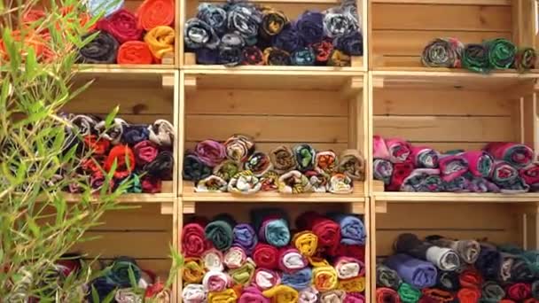 Kleurrijke sjaals te koop op een meubelstuk — Stockvideo